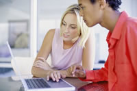 image of two students using a laptop