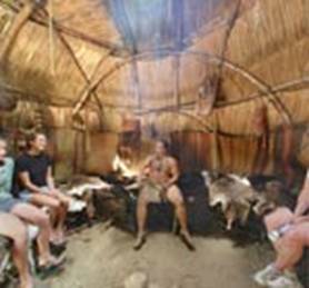 Wampanoag teaching visitors inside a wetu