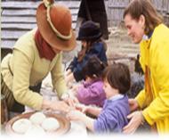 Colonist teaches a child how to make bread