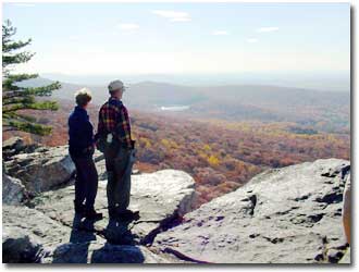 Two hikers looking out over the vast forests that are a part of the State Park
